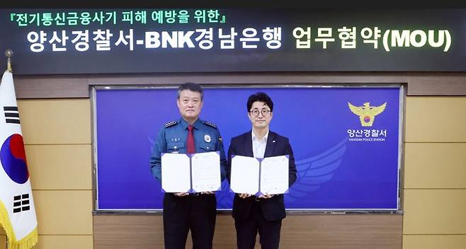 조필호 경남은행 금융센터장(오른쪽)과 김종규 양산경찰서장이 '전기통신 금융사기 피해 예방을 위한 업무 협약'을 체결하고 기념촬영을 하고 있다. BNK경남은행 제공