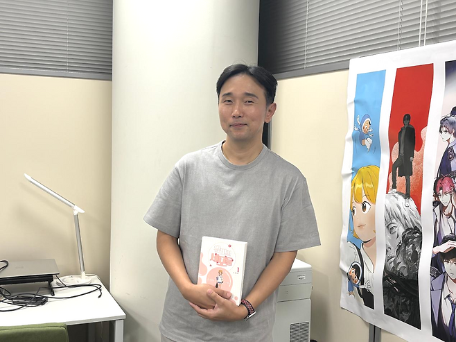웹툰 '유미의 세포들'의 이동건 작가가 21일 일본 도쿄 한국문화원에서 진행된 인터뷰에서 만화책을 들고 기념촬영을 하고 있다. 도쿄=류호 특파원
