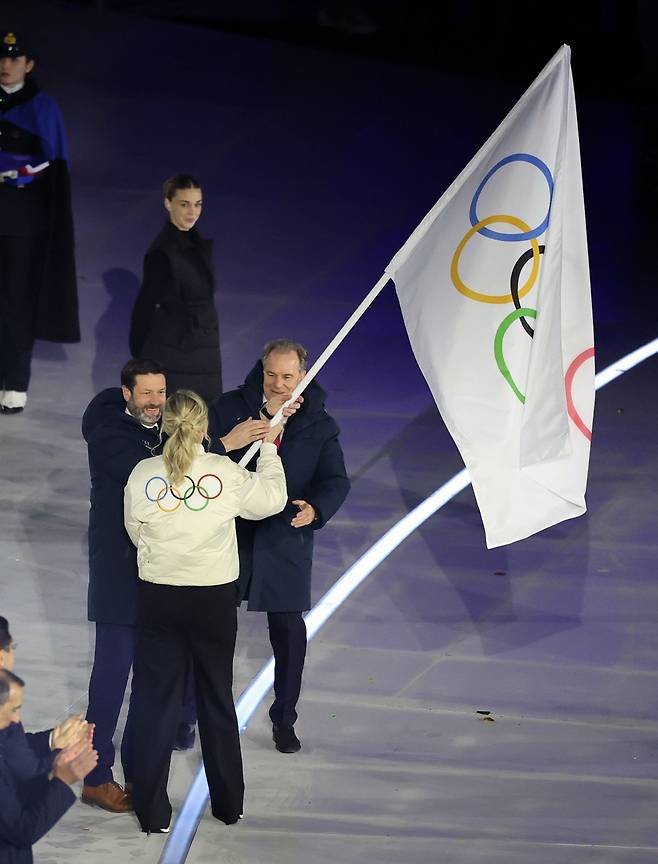 커스티 코번트리 국제올림픽위원회(IOC) 위원장이 22일(현지시간) 이탈리아 베로나 아레나에서 열린 2026 밀라노·코르티나담페초 동계올림픽 폐회식에서  2030년 차기 대회 개최지인 프랑스 알프스에 올림픽기를 전달하고 있다. 베로나=최현규 기자