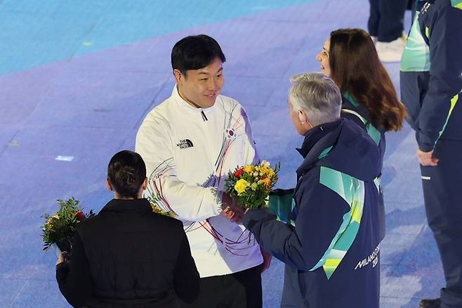 원윤종 신임 IOC 선수위원이 22일(현지시간) 이탈리아 베로나 아레나에서 열린 2026 밀라노 코르티나담페초 동계올림픽 폐회식에서 자원봉사자에게 꽃다발을 받고 있다. 연합뉴스