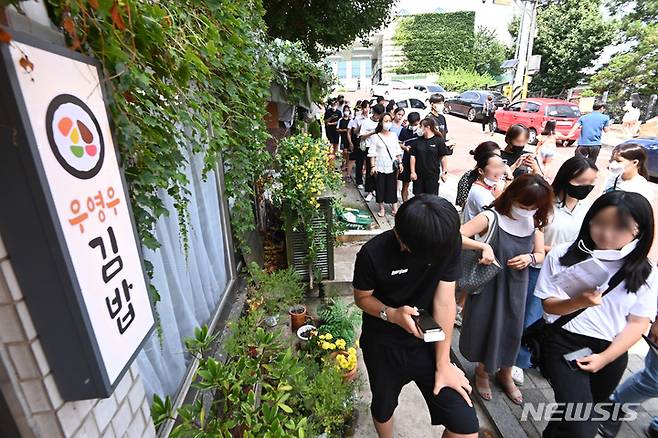 [수원=뉴시스] 김종택기자 = '이상한 변호사 우영우' 드라마 촬영지인 경기도 수원시 팔달구 행궁동 '우영우 김밥' 음식점 앞에 4일 오후 식사를 하거나 인증샷을 찍으려는 시민들로 붐비고 있다. 최근 '이상한 변호사 우영우' 드라마의 인기가 상승하면서 그동안 침체됐던 촬영지 일대 상권에 활력이 돌고 있다. 2022.08.04. jtk@newsis.com