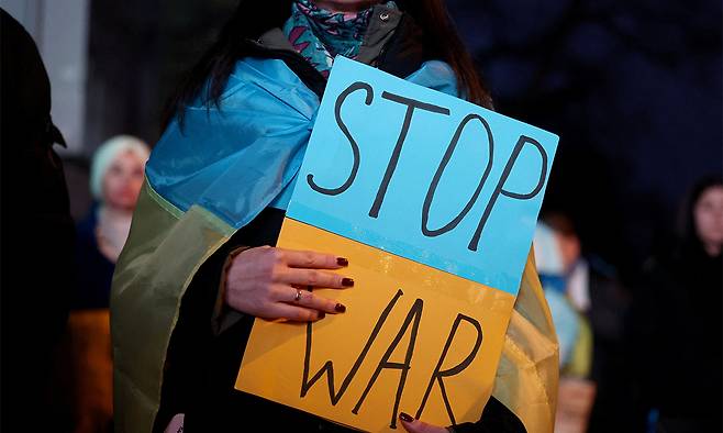 지난 2월 22일(현지시간) 러시아의 우크라이나 침공 4주년을 앞두고 헝가리 부다페스트에서 열린 행진에서 한 여성이 전쟁을 멈추라는 손팻말을 들고 있다. 로이터연합뉴스
