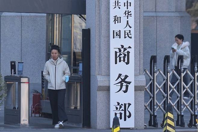 중국 베이징에 있는 상무부 청사에서 24일 한 여성이 나오고 있다. 상무부는 이날 일본 기업 40곳에 대해 희토류 등 이중용도 물자 수출을 통제하거나 관찰 대상에 넣는 등 제재를 가했다.(베이징/AP연합뉴스)