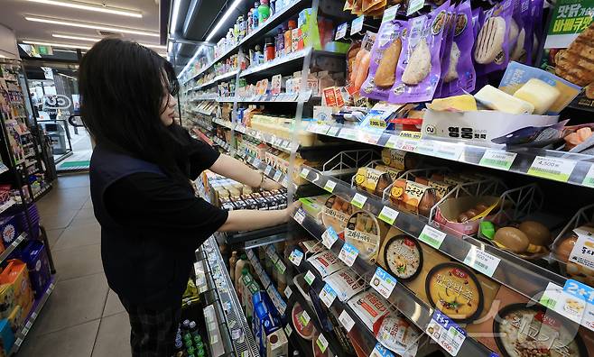 24일 서울 시내 한 편의점에서 직원이 진열된 제품을 정리하고 있다. 2025.7.24 ⓒ 뉴스1 김진환 기자