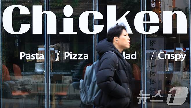 서울 시내의 한 치킨매장 앞으로 시민이 지나가고 있다. 2025.12.15 ⓒ 뉴스1 이호윤 기자