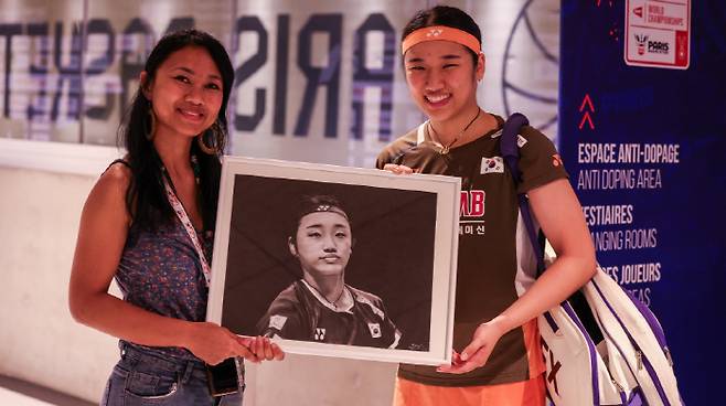 안세영(오른쪽)이 라자피니마나나의 초상화 작품을 들고 포즈를 쥐했다. 사진출처=BWF 홈페이지