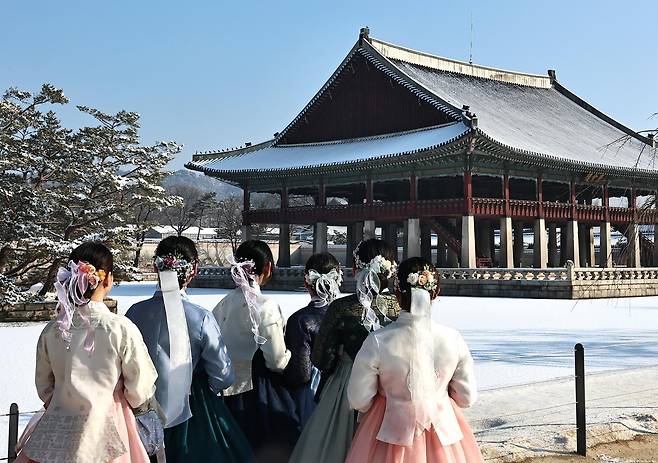 2일 오전 서울 종로구 경복궁을 찾은 외국인 관광객들이 눈 쌓이 경회루를 배경으로 기념촬영을 하고 있다.