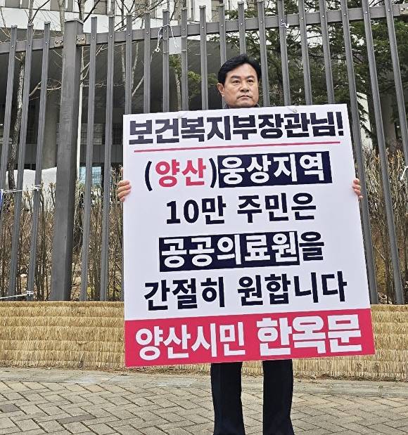 한옥문 국민의힘 양산시장 예비후보가 24일 세종특별시 보건복지부 청사 앞에서 '웅상지역 공공의료원 건립'을 촉구하는 1인 시위를 벌이고 있다. [사진=한옥문 예비후보 캠프]