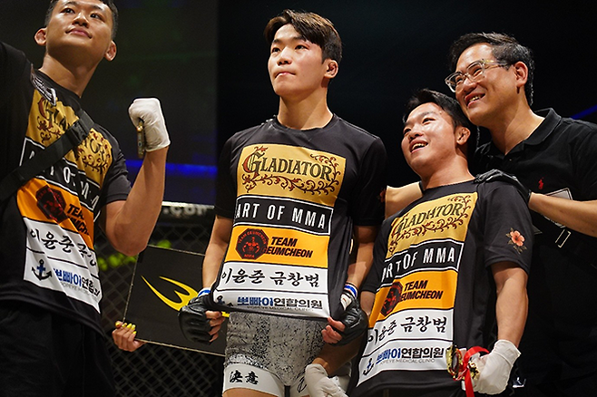 KMMA 페더급 챔피언이 되는 김지경이 2025년 9월 일본 오사카 글래디에이터 032에서 종합격투기 프로 데뷔승 기념 촬영을 하고 있다. 오른쪽은 로드FC 플라이급 챔피언 이정현, KMMA 정용준 공동대표. 사진=대구반월당역 뽀빠이연합의원 제공