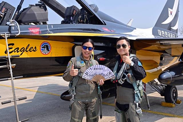 블랙이글스가 한국 복귀 길인 지난 18일 태국 치앙마이 공군기지에서 한·태 공군 우정비행을 마친 뒤, 블랙이글스 김주호 대위가 후방석에 동승한 태국 공군 깐차녹 짠야락 소령에게 기념품을 전달한 뒤 기념 촬영하고 있다. C-130H 수송기 부조종사인 깐차녹 짠야락 소령은 이번 비행으로 태국 공군에서 T-50 계열 항공기에 탑승한 최초의 여성 조종사가 됐다. 공군 제공