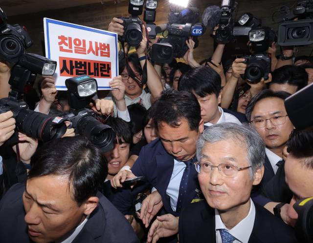 ▲조희대 대법원장이 13일 서울 여의도 국회에서 열린 대법원 등에 대한 법제사법위원회 국정감사에서 정회가 선언되자 법사위 회의실을 나서고 있다. 왼쪽 위는 조 대법원장의 이석에 반대하며 무소속 최혁진 의원이 든 규탄 팻말. ⓒ연합뉴스