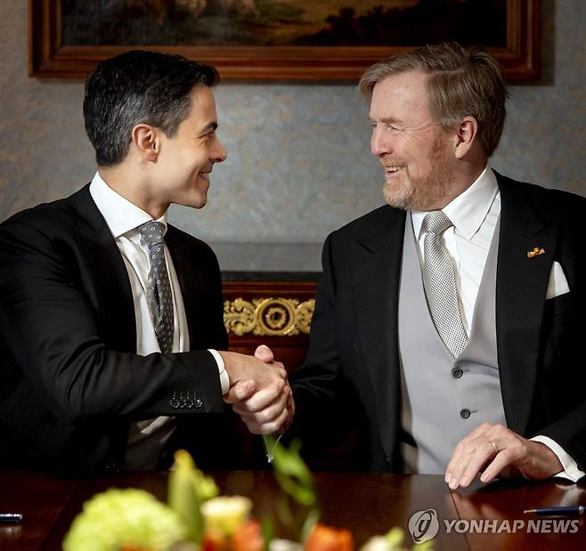 23일 신임 총리 롭 예턴과 악수하는 빌럼 알렉산더르 네덜란드 국왕(오른쪽) [EPA=연합뉴스. 재판매 및 DB 금지]