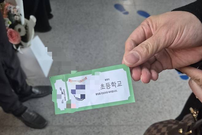 지난 12일 서울 강동구의 한 초등학교 체육관에서 졸업식이 열린 가운데 학교 측이 졸업생 한 명당 학부모 한 명만 입장을 허용하면서 학교 측이 학부모에게 배부한 입장권. 이 입장권이 있어야 졸업식장에 들어갈 수 있다./권우석 기자