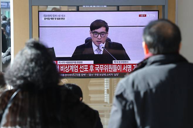 People watch the live broadcast of the first trial verdict for former President Yoon Suk Yeol at Seoul Station on Jan. 16. [NEWS1]