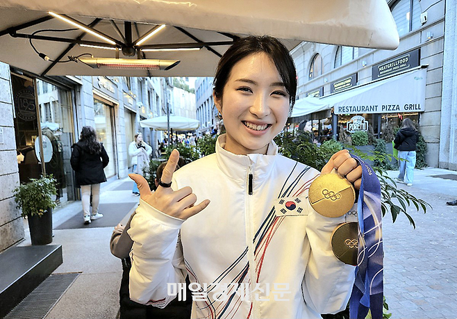 쇼트트랙 국가대표 김길리가 22일(한국시간) 이탈리아 밀라노의 한 카페에서 매일경제와 단독 인터뷰한 뒤 금메달 2개를 들어보이면서 자신의 시그니처 포즈를 선보이고 있다. 그는 해당 포즈에 대해 “내 느낌을 표현한 것”이라고 밝혔다. 밀라노 김지한 기자