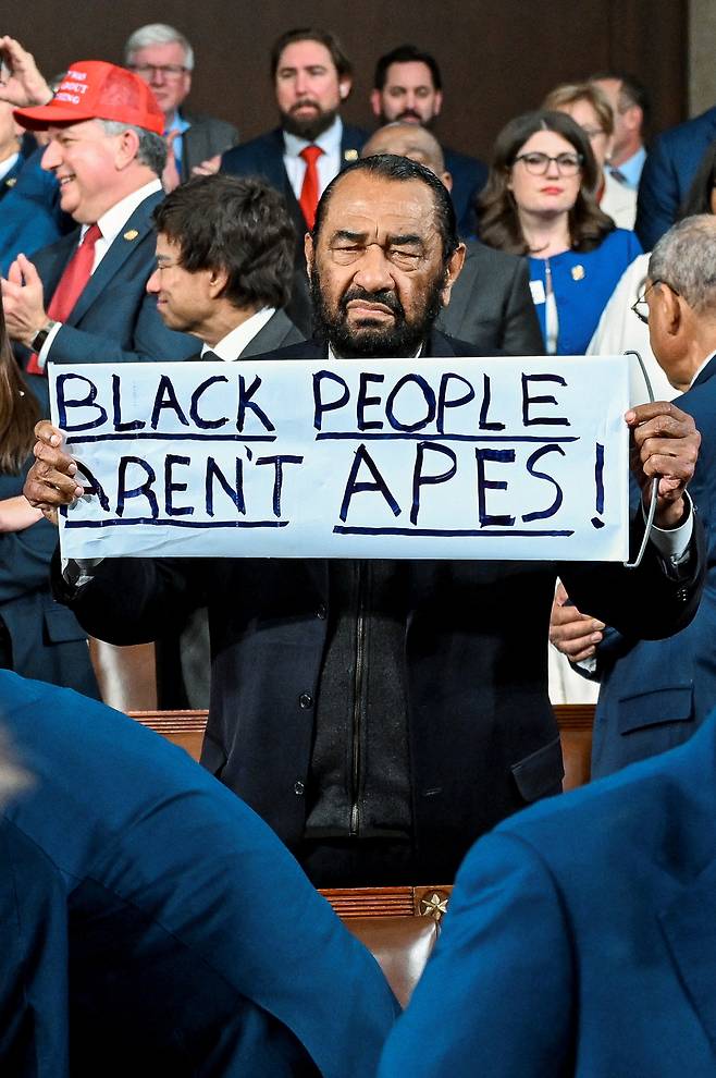 앨 그린(민주·텍사스) 미국 하원의원은 24일(현지시간) 미국 워싱턴DC 연방 의회 의사당에서 열린 도널드 트럼프 대통령의 집권 2기 첫 국정연설 도중 ‘흑인은 유인원이 아니다’는 손팻말을 들어보이고 있다. [로이터]