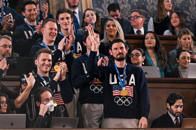 미국 수도 워싱턴 D.C.의 국회의사당 하원 회의장에서 미국 남자 아이스하키 대표팀 선수들이 도널드 트럼프 대통령을 비롯한 민주당원과 공화당원들의 환호 속에서 손을 흔들고 있다. [로이터]