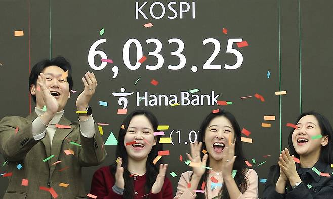 코스피가 장중 6000을 넘어선 가운데 25일 서울 중구 하나은행 본점 딜링룸에서 직원들이 기뻐하고 있다. 연합뉴스