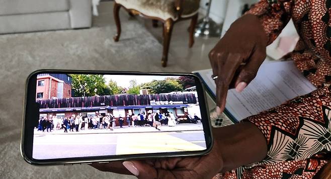 차바 여사가 한 음식점 주변에서 찍은 인파 사진을 보여주고 있다. 이런 장면이 처음에는 신기하게 보였다고 말했다. [촬영 박세진 기자]