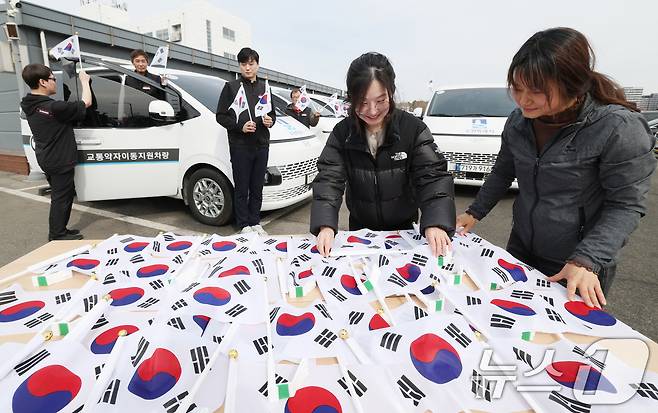 제107주년 3·1절을 사흘 앞둔 26일 경기 수원시 권선구 수원시교통약자지원센터 한아름콜에서 직원들이 3·1절을 맞아 교통약자지원차량에 부착할 태극기를 준비하고 있다. 2026.2.26 ⓒ 뉴스1 김영운 기자