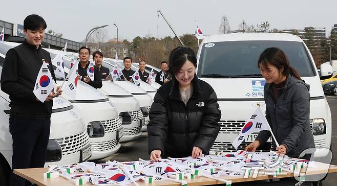 제107주년 3·1절을 사흘 앞둔 26일 경기 수원시 권선구 수원시교통약자지원센터 한아름콜에서 직원들이 3·1절을 맞아 교통약자지원차량에 부착할 태극기를 준비하고 있다. 2026.2.26 ⓒ 뉴스1 김영운 기자