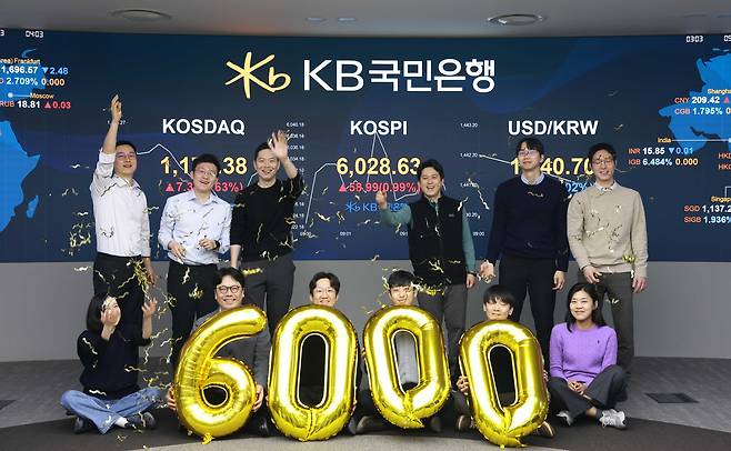 코스피가 장 시작과 함께 6000선을 돌파한 25일 오전 서울 영등포구 KB국민은행 딜링룸에서 직원들이 축하 세리머니를 하고 있다./KB국민은행 제공