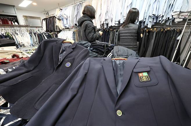 교육 당국이 교복 가격을 바로잡기 위해 전국 학교를 상대로 한 교복비 전수조사에 들어간 가운데 23일 관내 학교와 졸업생에게 교복을 기증받아 필요로 하는 주민에게 저렴하게 판매하는 서울 송파구 '나눔교복매장'을 찾은 학부모가 교복 등을 살펴보고 있다.   이재명 대통령은 지난 12일 "최근 교복 구입비가 60만원에 육박한다고 한다"며 "개학을 앞둔 만큼 교복 가격의 적정성 문제를 한번 살펴봐 달라"고 지시했다. 연합뉴스