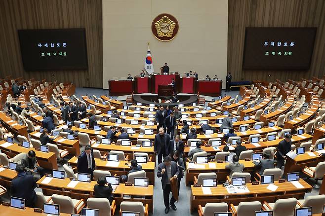 지난 25일 국회에서 열린 2월 임시국회 본회의에 ‘법왜곡죄’를 포함한 형법 일부개정법률안(대안)이 상정된 뒤 조배숙 국민의힘 의원이 무제한 토론을 시작하자 더불어민주당 의원들이 본회의장을 떠나고 있다. [연합뉴스]