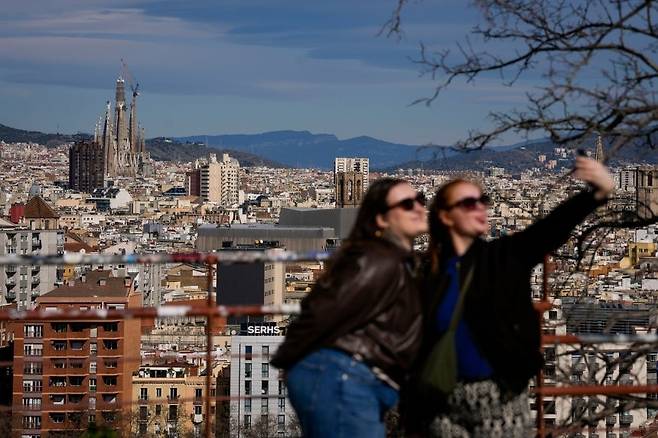 지난 20일(현지시간) 스페인 바르셀로나 사그라다 파밀리아 성당 앞에서 두 여성이 기념사진을 찍고 있다. [AFP]