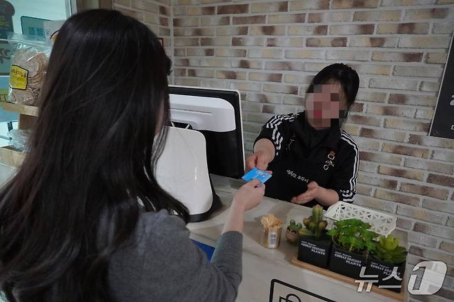 27일 점심시간 충남 청양군 청양읍의 한 식당에서 군청 직원이 기본소득 선불카드로 계산하고 있다. 2026.2.27 ⓒ 뉴스1 최형욱 기자