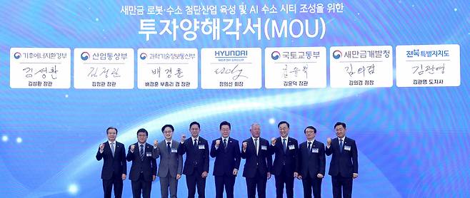 이재명 대통령이 27일 전북 군산 새만금 컨벤션센터에서 열린 ‘새만금 로봇·수소 첨단산업 육성 및 AI 수소 시티 조성’ 투자협약식에 참석해 주요 관계자들과 기념촬영을 하고 있다. 사진 왼쪽부터 김용범 대통령비서실 정책실장, 김성환 기후에너지환경부 장관, 김정관 산업통상자원부 장관, 배경훈 부총리 겸 과학기술정보통신부 장관, 이재명 대통령, 정의선 현대자동차그룹 회장, 김윤덕 국토교통부 장관, 김의겸 새만금개발청장, 김관영 전북도지사. 청와대사진기자단