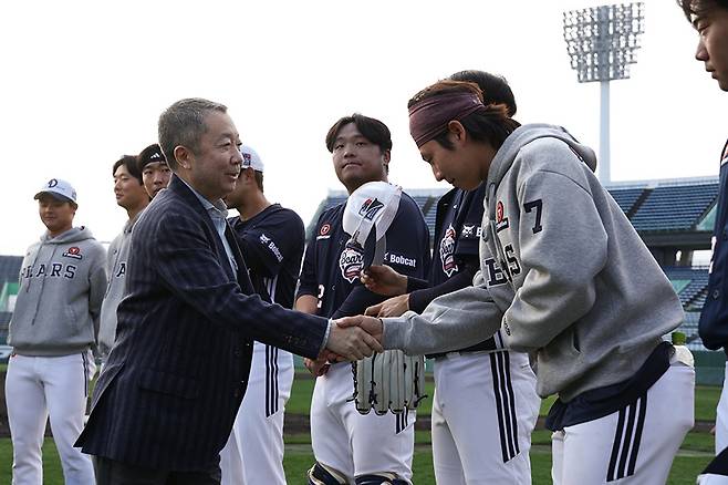 박정원 두산 구단주(왼쪽)가 25일 일본 미야자키 스프링 캠프 현장에서 박찬호와 악수하고 있다.  두산베어스 제공