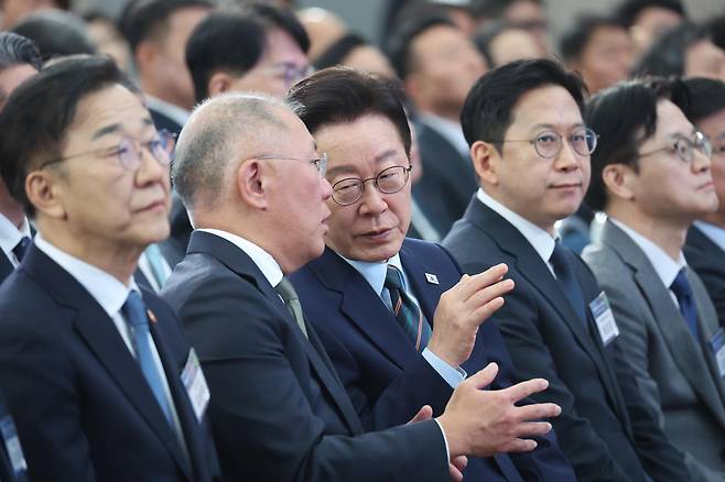 이재명 대통령이 27일 전북 군산새만금컨벤션센터에서 열린 새만금 로봇·수소·AI 시티 투자협약식에서 정의선 현대차그룹 회장과 대화하고 있다. 연합뉴스