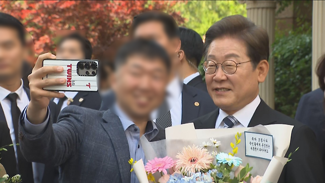 지난해 6월 4일 대통령 취임식을 앞두고 자택을 나서며 지지자와 사진을 찍는 이재명 대통령.