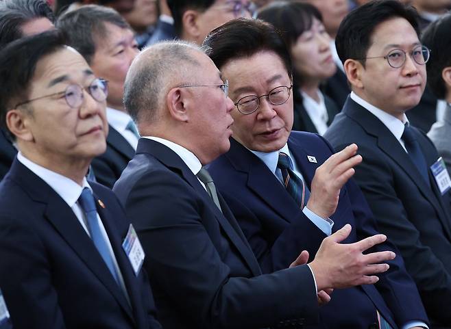 이재명 대통령이 27일 전북 군산 새만금 컨벤션센터에서 열린 ‘새만금 로봇·수소·AI 시티 투자 협약식’에서 정의선 현대차그룹 회장(왼쪽 둘째)과 대화를 나누고 있다. 현대차는 이날 새만금에 약 9조원을 투자해 로봇과 인공지능(AI), 수소 분야 혁신 거점을 구축하겠다고 발표했다. [청와대사진기자단]