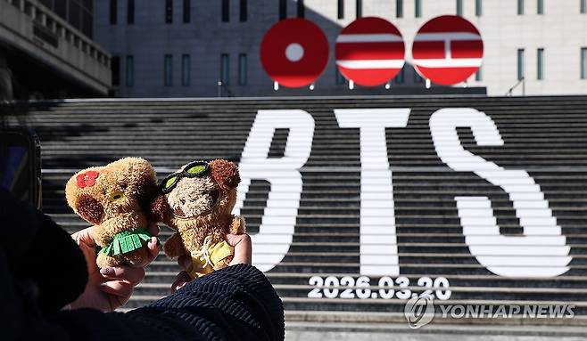 식지 않은 BTS 인기 (서울=연합뉴스) 김인철 기자 = 22일 서울 종로구 세종문화회관 계단에서 외국인 관광객들이 오는 3월 3년 9개월 만에 '완전체'로 돌아오는 그룹 방탄소년단(BTS)의 컴백을 알리는 홍보물을 기념촬영하고 있다. 2026.1.22 yatoya@yna.co.kr