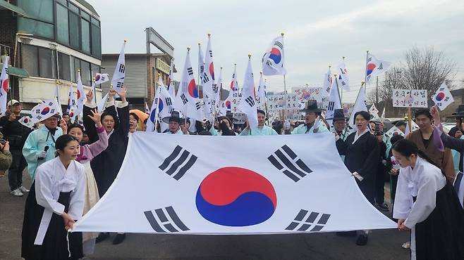 ▲ 전통 의상을 입은 재연단과 시민들이 태극기를 흔들며 "대한독립 만세"를 외치고 있다. 현장에는 107년 전 가래비 만세운동의 긴박했던 분위기가 재현됐다.
