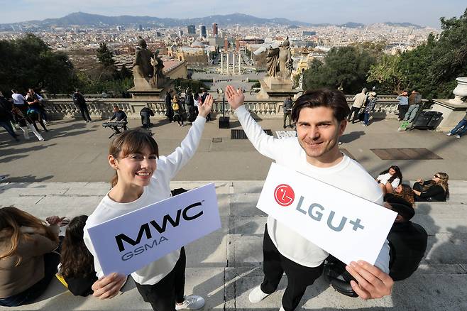 지난 27일(현지시간) 모바일월드콩그레스(MWC) 2026이 열리는 스페인 바르셀로나에서 LG유플러스 현지 관계자들이 바르셀로나 시내를 배경으로 사진 촬영을 하며 행사 개막을 알리고 있다./사진공동취재단