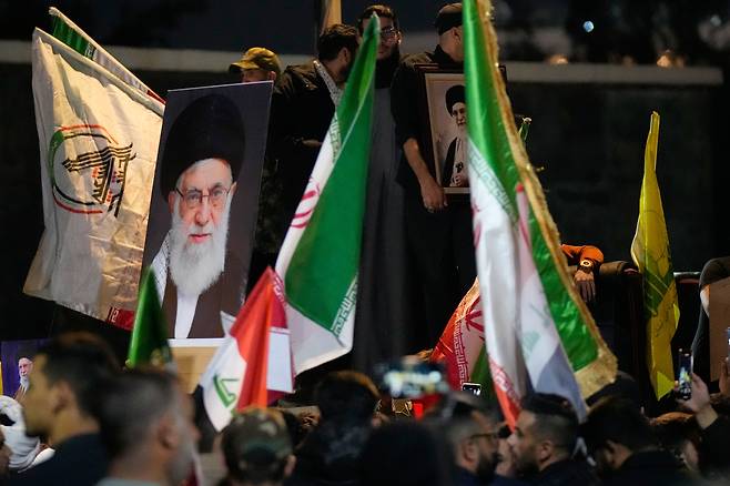 이라크 바그다드에서 28일(현지시간) 미국과 이스라엘의 대이란 공격에 대한 반대 시위가 열린 가운데 시위대가 이란 최고지도자 하메네이의 초상화를 들고 있다. [AFP]