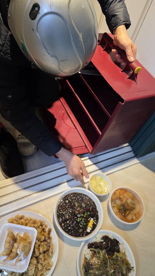 철가방에서 음식을 꺼내시는 사장님.