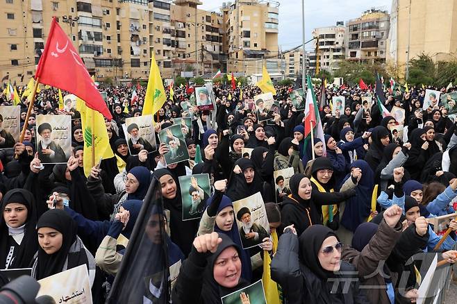 미구과 이스라엘의 공습으로 이란에서 암살된 최고지도자를 추모하기 위해 2026년 3월 1일 베이루트 남부 교외에서 열린 집회에서 레바논 시아파 무장정파 헤즈볼라 지지자들이 구호를 외치고 있다. ⓒ AFP=뉴스1