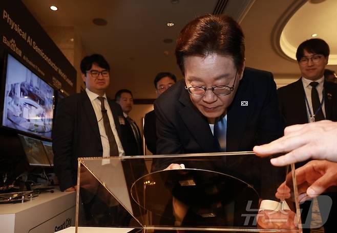 이재명 대통령이 2일(현지시간) 싱가포르 한 호텔에서 열린 한·싱가포르 AI 커넥트 서밋 종료 후 전시 부스에서 웨이퍼에 서명하고 있다. 2026.3.2 ⓒ 뉴스1 허경 기자