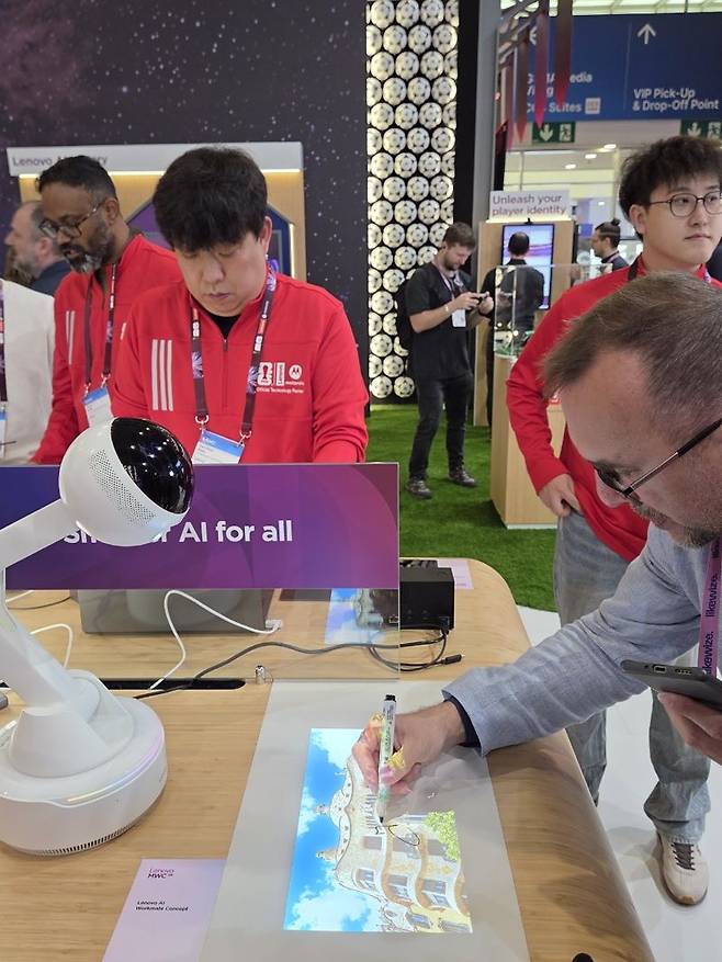MWC 2026이 열린 스페인 바르셀로나 피라그란비아 레노버 전시관에서 관람객이 워크메이트 로봇을 체험하고 있다. 사진=장민권 기자