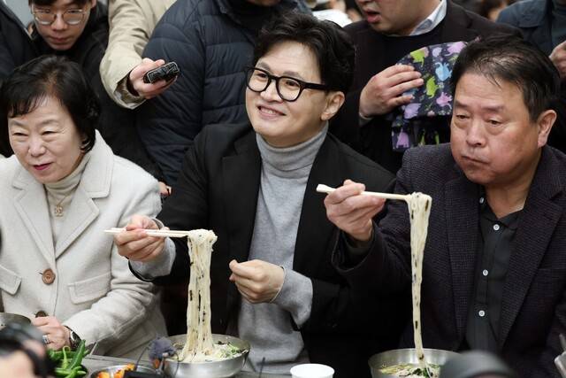 한동훈 전 국민의힘 대표가 지난 27일 오후 대구 서문시장을 찾은 자리에서 일행들과 국수를 먹고 있다. 연합뉴스