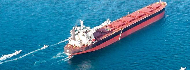 지난달 17일 호르무즈해협에서 이란혁명수비대(IRGC)가 군사 훈련을 벌이는 가운데 유조선 한 척이 해협을 통과하고 있다.   AFP연합뉴스