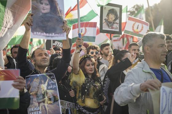 People hold portraits of Mahsa Amini during a protest against the Iranian regime in Berlin on Oct. 22, 2022, following the death of Amini in the custody of the country's ″morality police″ on Sept. 16 after her arrest three days prior for allegedly violating its strictly-enforced dress code. [AP/YONHAP]