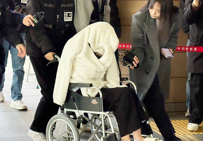 약물을 투약한 상태로 차량을 몰다 반포대교 난간을 뚫고 추락한 30대 여성 A씨가 지난달 27일 서울 마포구 서울서부지법에서 열린 구속 전 피의자 심문(영장실질심사)에 휠체어를 타고 출석하는 모습. 뉴스1