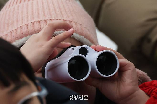 한 어린이가 망원경을 사용하고 있다.