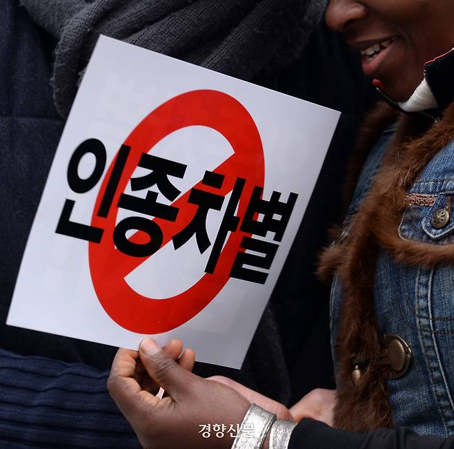 2016년 3월 13일 서울 보신각앞에서 열린 ‘인종차별 철폐의 날’ 행사에 참석한 한 이주노동자가 ‘인종차별 금지’라고 적힌 손팻말을 들고 자리에 앉아 있다. 그해 3월 21일은 UN이 제정한 ‘인종차별 철폐의 날’ 50주년이다. 서성일 기자