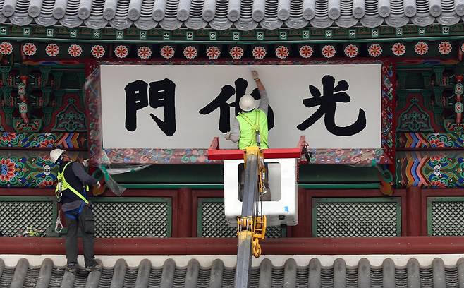 Officials repaint the Gwanghwamun nameboard in Jongno District, central Seoul, on March 29, 2016. [KIM SANG-SEON]